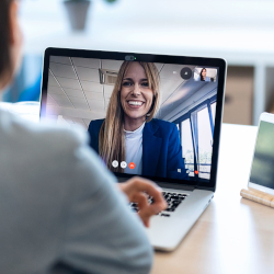 Smiling woman participating in a video conference on a laptop