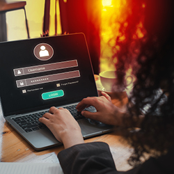 A person types their username and password on a laptop login screen