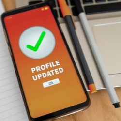 Ein Smartphone auf einem Schreibtisch zeigt ein erfolgreich abgeschlossenes Update