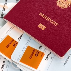 A close-up of a passport with two printed flight tickets inside
